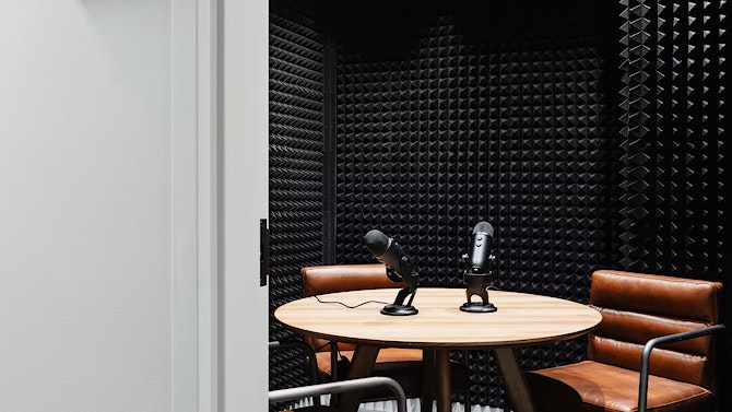 A small table with microphones in a podcast room.